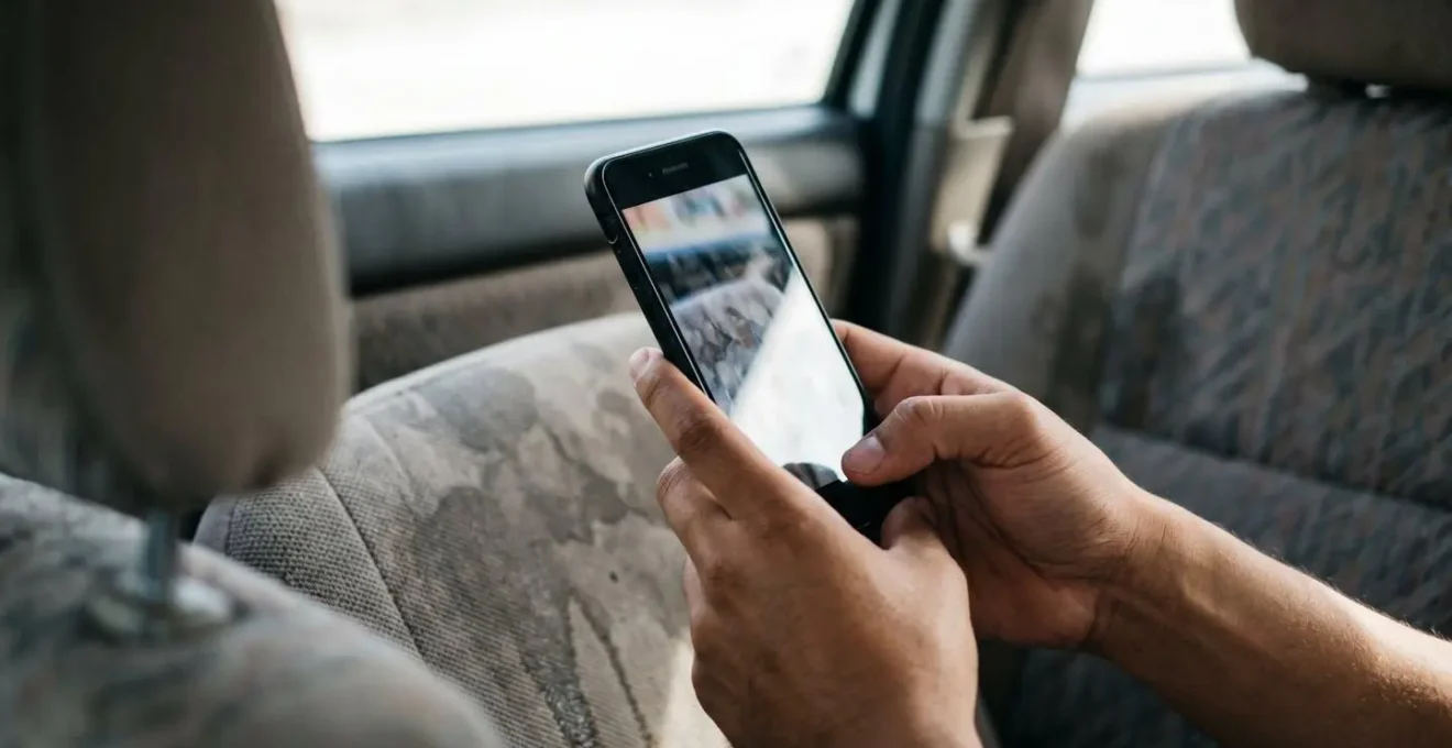 Main tenant un smartphone photographiant des dommages sur un véhicule pour constituer un dossier de preuves numériques
