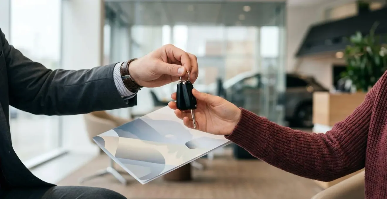 Échange de clés de voiture entre concessionnaire et client avec documents d'assurance